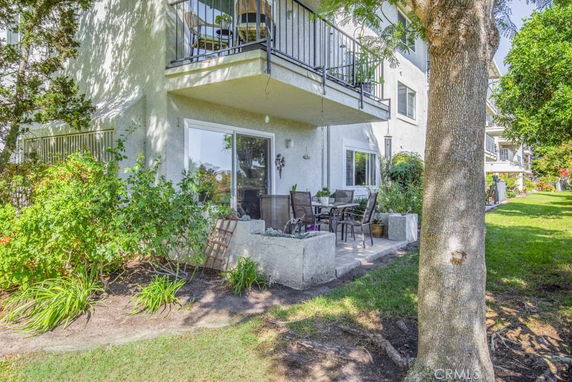 Exterior view of a multi-story building with balconies and patio area.
