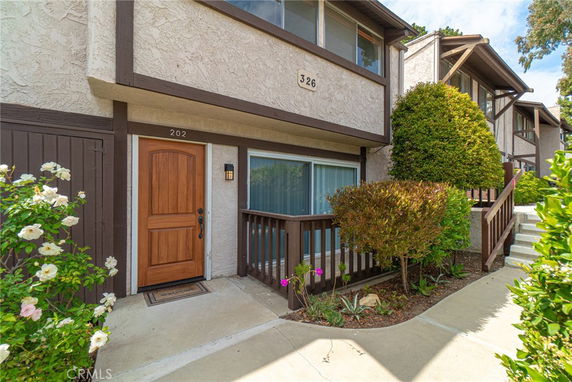 Front view of a townhouse with a wooden door and window.