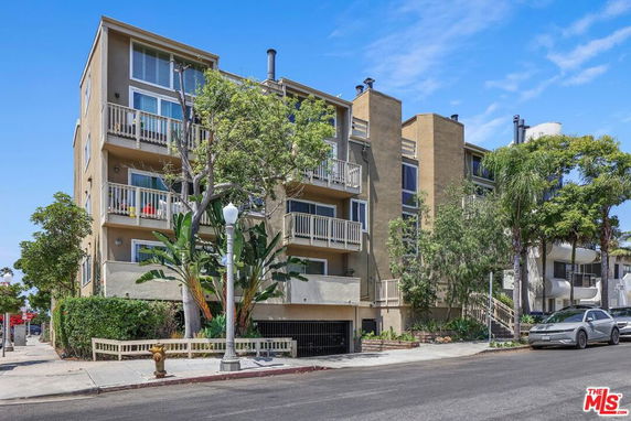 Front view of a multi-story apartment building with balconies.