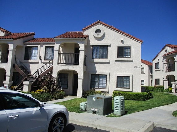 Front view of a two-story building with a staircase and red tiled roof.