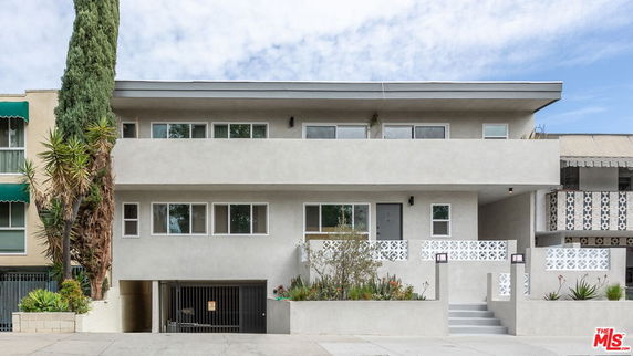 Front view of a modern two-story apartment building with a garage.