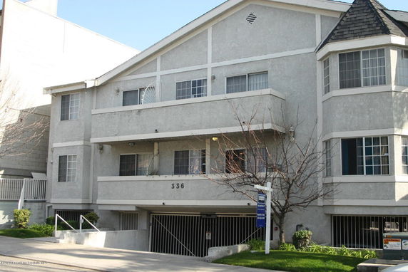 Front view of a multi-story apartment building with a gated entrance.