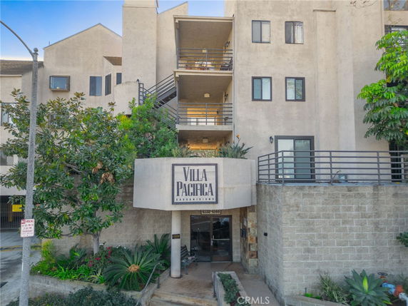 Front view of a multi-story condominium building with a sign reading 'Villa Pacifica Condominiums'.