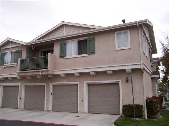 Front view of a two-story house with a three-car garage and a small balcony.