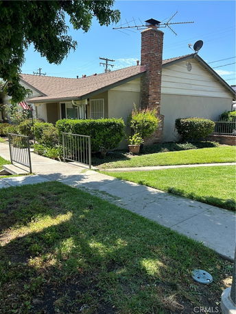 Front view of a single-story house with a chimney and antenna.