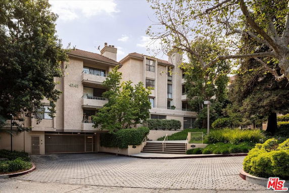 Front view of a multi-story building with balconies and an entryway.