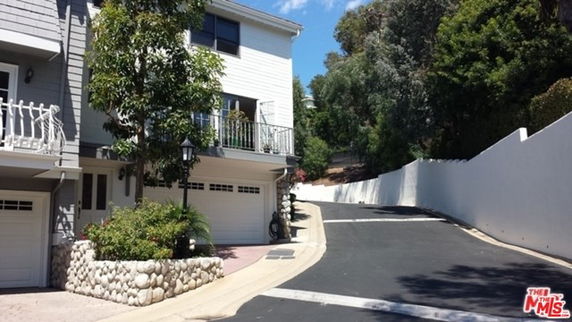Front view of a multi-story house with a garage and driveway.