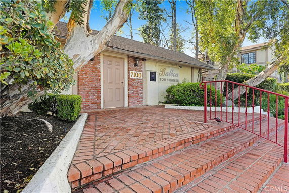 Front view of a building entrance with brick walkway and 'Balboa Townhomes' sign.