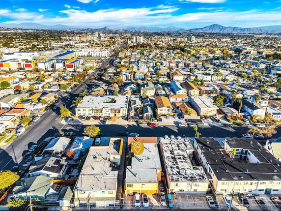 Aerial view of a sprawling urban landscape with numerous residential buildings and distant mountains.