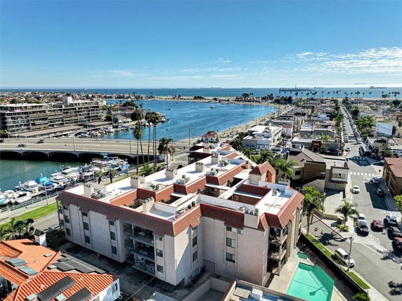 Panoramic view of a coastal cityscape with a body of water, buildings, and a bridge.