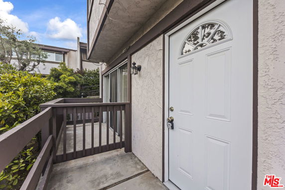 Entryway of a house with a white front door and small concrete porch.