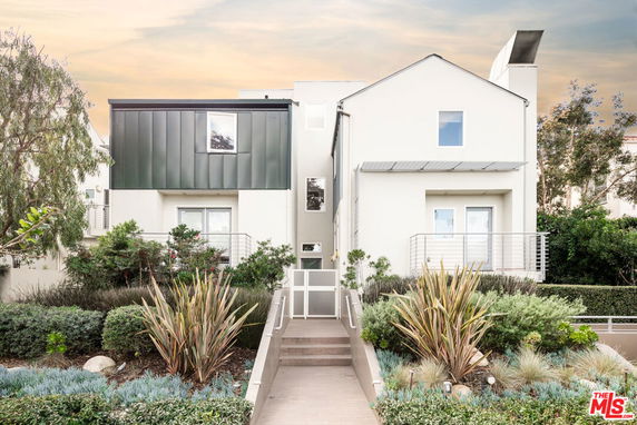 Front view of a modern two-story house with a metal-accented facade