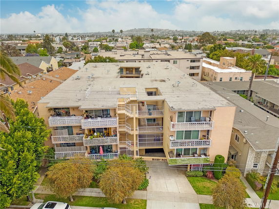 Front view of a multi-story residential building with balconies and a central staircase.