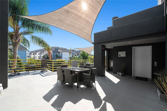Rooftop area with shade sails and outdoor seating.
