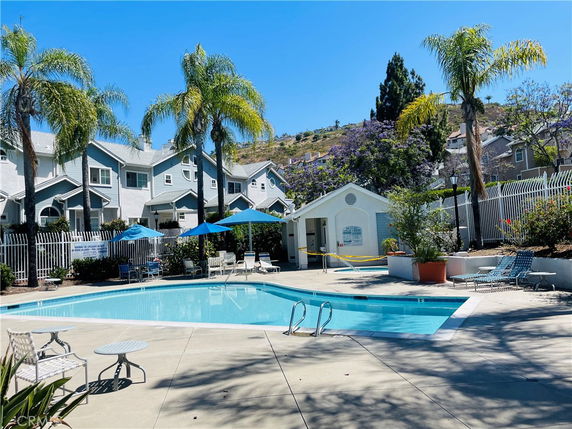 Outdoor swimming pool area with surrounding residential buildings.