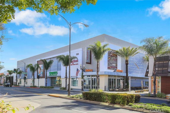 Front view of a commercial building with multiple storefronts and large windows.