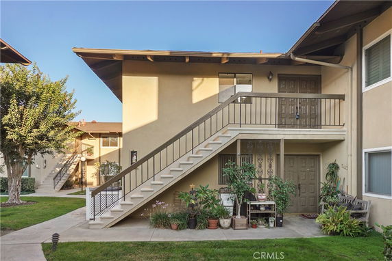 Front view of a two-story building with an exterior staircase leading to the upper floor.