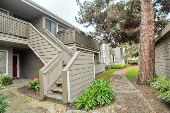 Exterior view of a two-story building with wooden siding and stair access to the second floor.