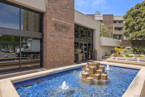 Front view of a building with a fountain in front.
