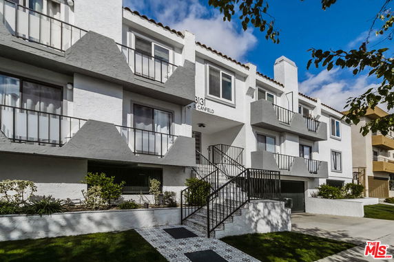Front view of a multi-story apartment building with balconies.