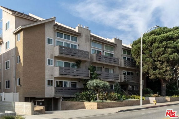 Front view of a multi-story apartment building with balconies.