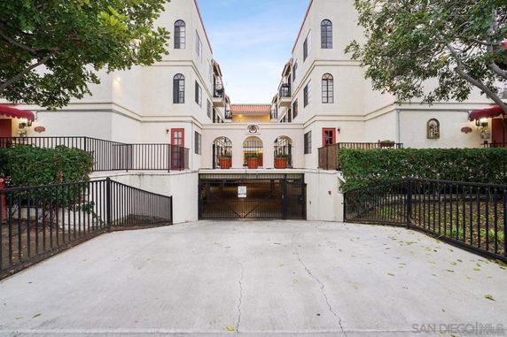 Front view of a multi-story residential building with gated entrance.