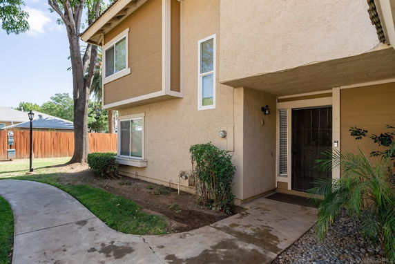 Front view of a two-story house with a pathway leading to the entrance.
