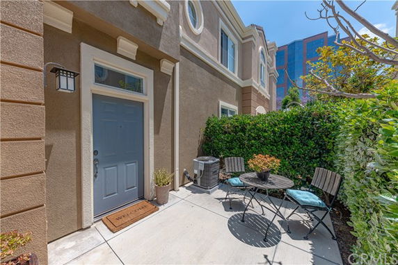 Front view of a townhouse with a small patio area and blue door.