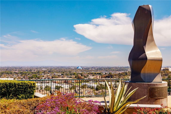 View of surrounding areas from a high vantage point with a sculpture in the foreground.
