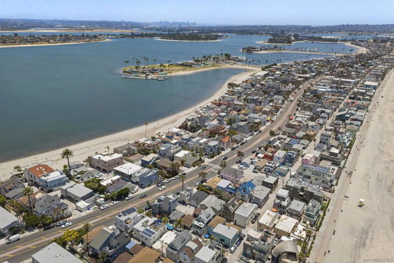 Panoramic view of a coastal town with houses, beach, and waterfront.