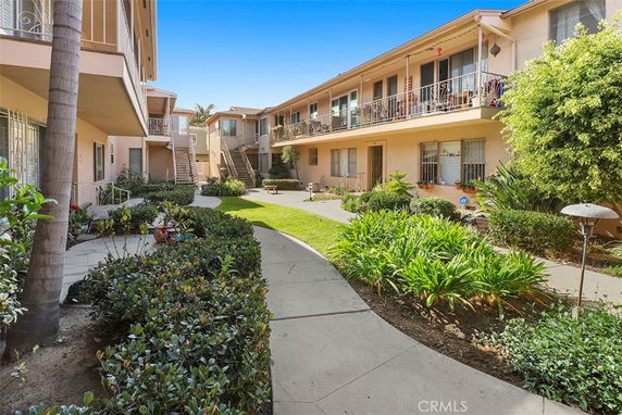 Front view of an apartment building with balconies and a walkway.