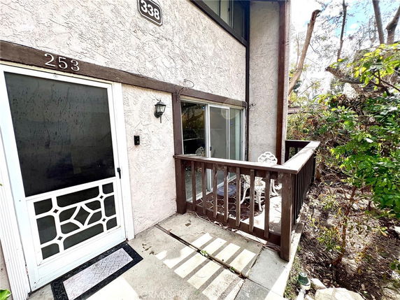 Front view of a house with a small patio and sliding glass door.
