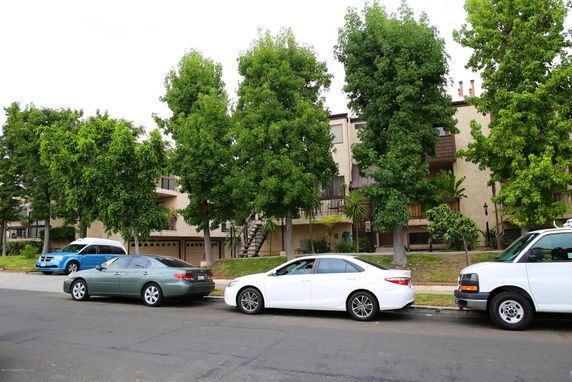 Front view of a residential building with balconies and a staircase.