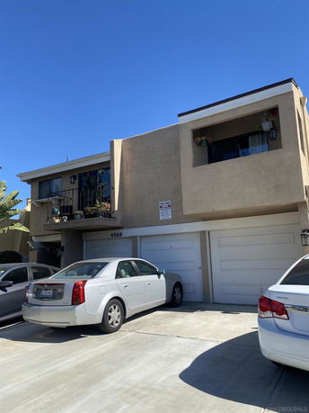 Front view of a two-story house with balconies and a double garage.