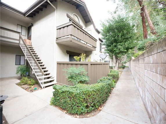 Front view of a multi-story apartment building with exterior stairs and balconies.