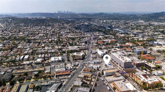 Aerial panoramic view of a large cityscape with numerous buildings and distant skyline.