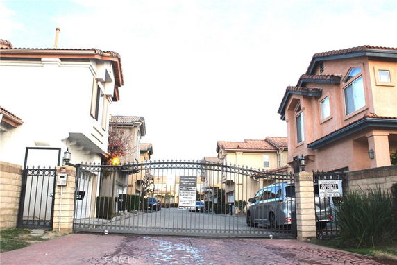 Front view of a gated residential complex with multiple two-story houses.