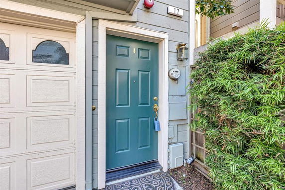 Front view of a house with a teal-colored door and adjacent garage.