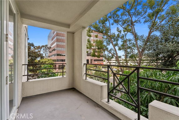 Panoramic view from a balcony overlooking city buildings and trees.