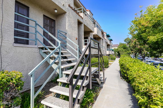 Front view of a multi-story building with exterior staircases and balconies.