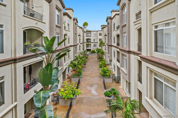 View of apartment building courtyard with balconies and plants.