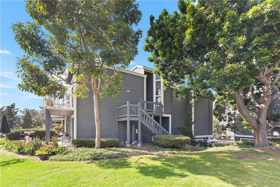 Front view of a multi-story house with gray exterior and balconies.