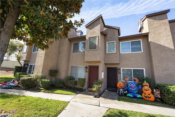 Front view of a two-story townhouse with Halloween decorations outside.