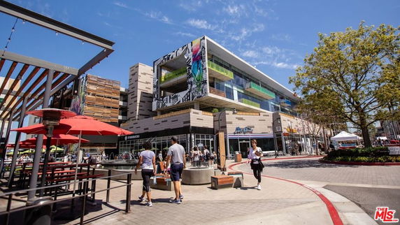 Front view of a modern multi-story commercial building with artistic designs on the facade.