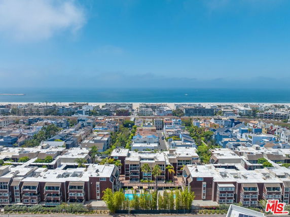 Panoramic view of a coastal residential area with buildings and the ocean in the background.
