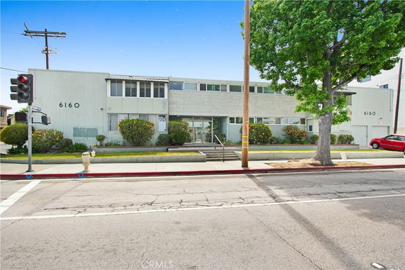 Front view of a two-story commercial building with large windows and an entrance staircase.