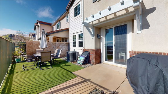 Front view of a multi-story house with patio area.