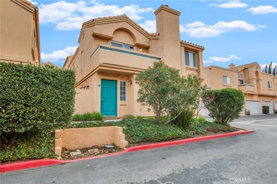 Front view of a two-story house with a teal front door and garage.