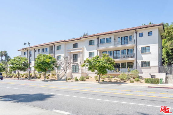 Front view of a multi-story residential building with balconies.