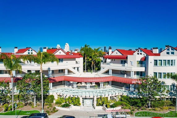Front view of a large multi-story residential building with red roofs and white exterior.